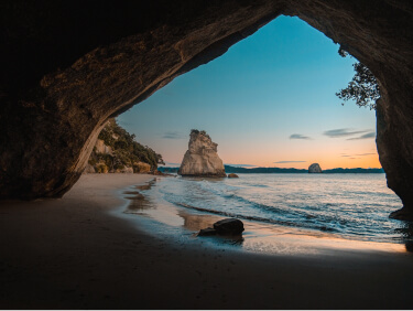 A beach cove overlooking an ocean sunset.